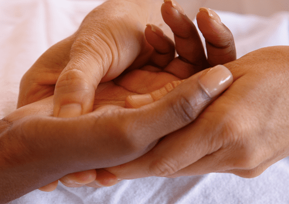 A woman enjoying a hand reflexology session