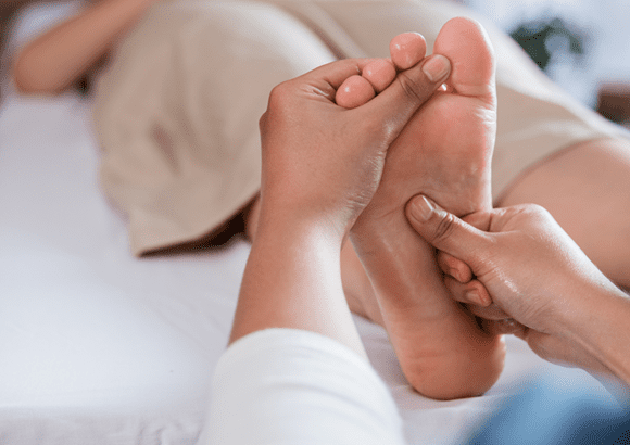 A woman enjoying a foot reflexology session