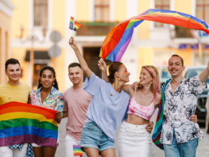 A group of LGBTQ friends walking with pride flags