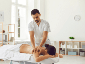 A male massage therapist giving a woman a massage at her home in Los Angeles