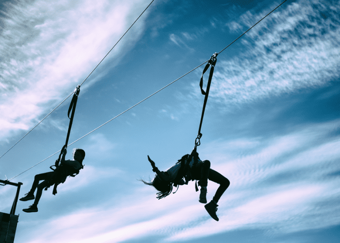 This picture of two people ziplining The LINQ and SlotZilla represents something cool and crazy for couples to do in Las Vegas