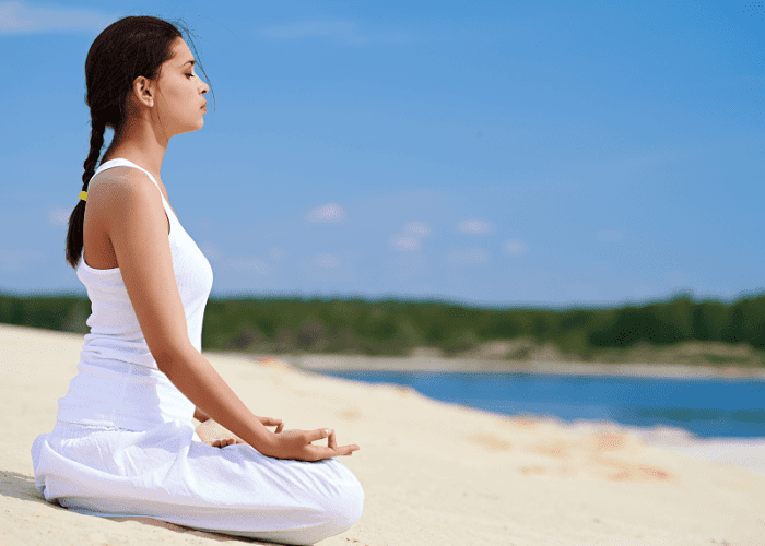 An in-home massage therapist meditating at the beach in Los Angeles