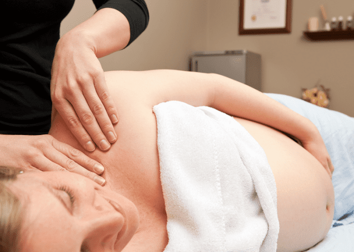 A woman getting a prenatal mobile massage at home in Los Angeles