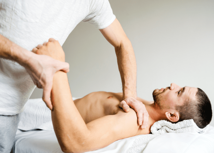 A man receiving a sports massage at his home in Los Angeles from a male sports massage therapist