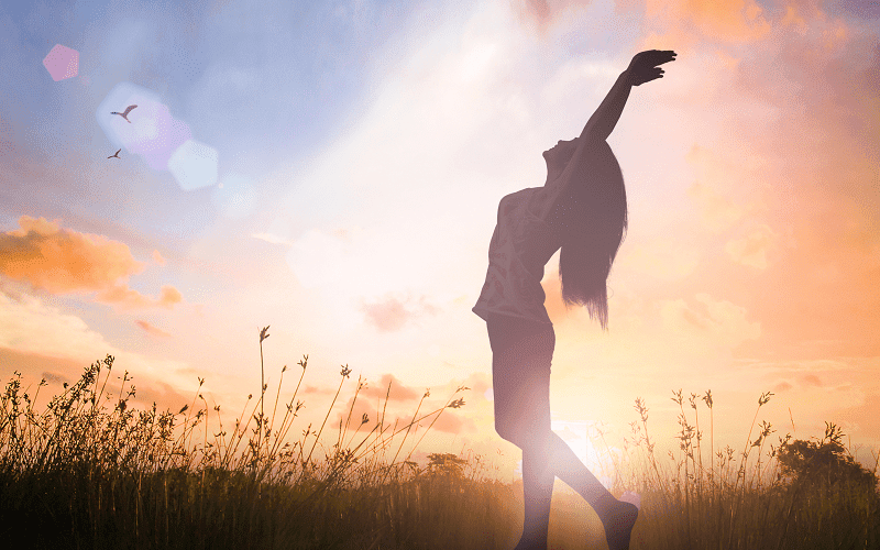 Silhouette of a woman from Las Vegas at the park in Los Angeles experiencing mental and physical well-being after getting a mobile massage